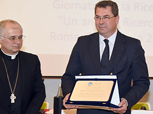 La consegna del premio a Niccol&ograve; Contucci di Airc da parte di monsignor Claudio Goiuliodori